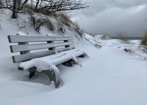 Snow covered bench along Lake Michigan